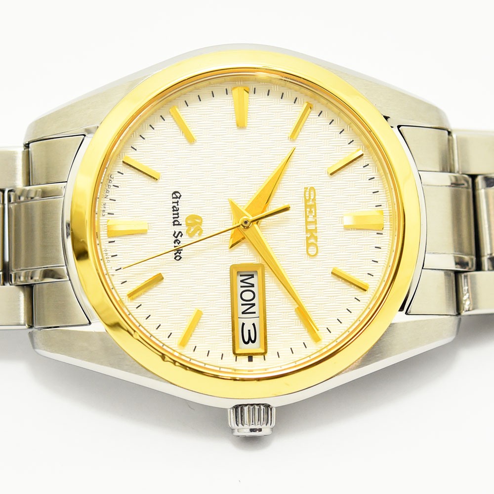 VINTAGE WATCHES FASHIONのグランドセイコーメンズ腕時計。シルバーのステンレスケースにゴールドのベゼルとインデックスが映える、繊細なパターンの文字盤を備えた高級感あるデザイン。
