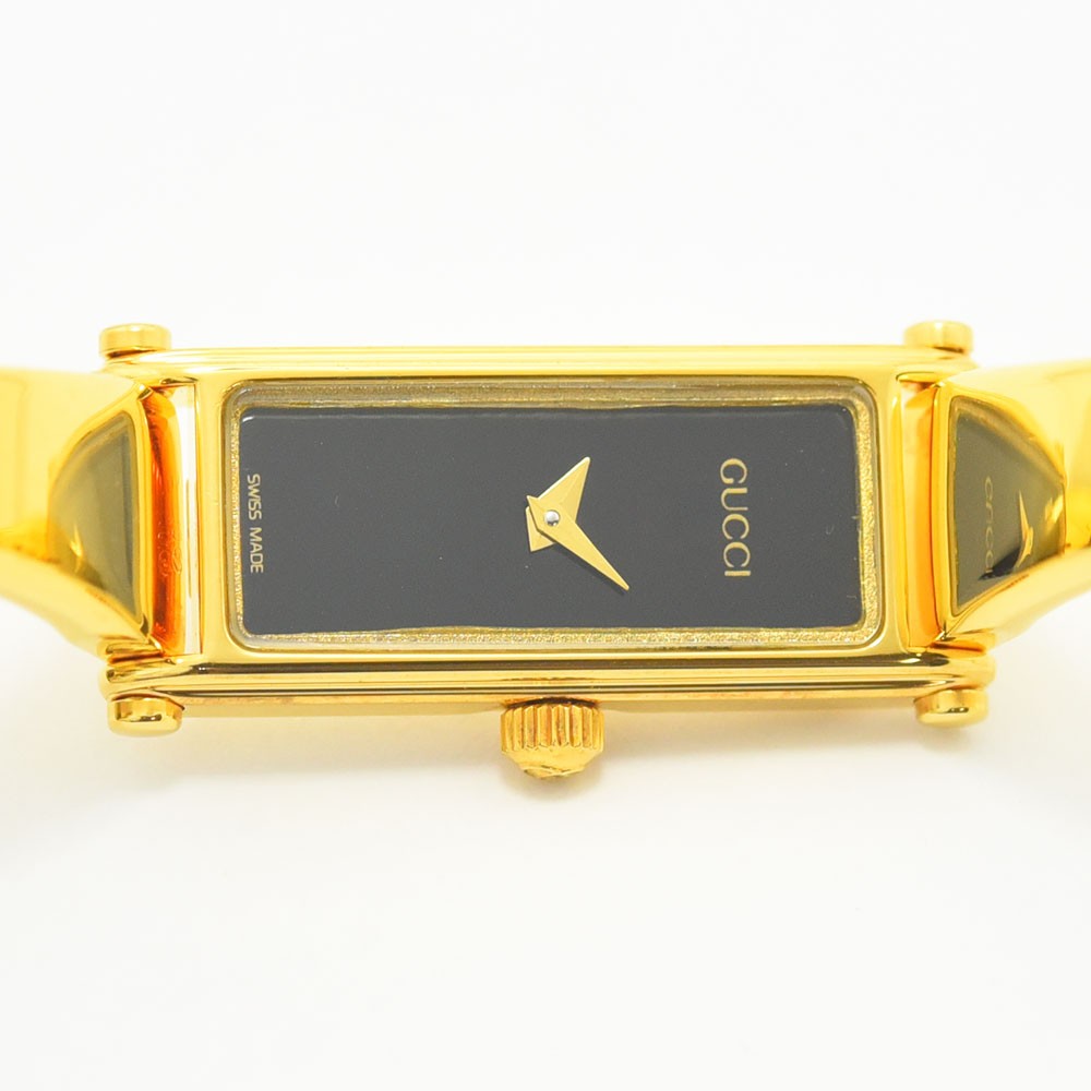 VINTAGE WATCHES FASHIONのGUCCI 1500シリーズ、ゴールドカラーのバングル型レディース腕時計。ブラックの長方形文字盤が特徴。