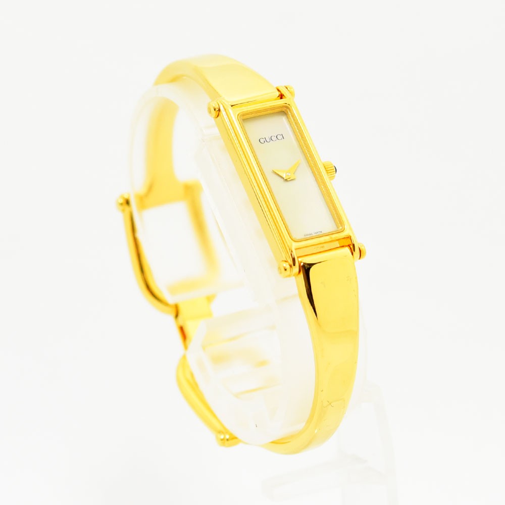 VINTAGE WATCHES FASHIONのGUCCI 1500Lレディースバングルウォッチ。ゴールドカラーの長方形ケースとミニマルな文字盤が特徴の高級腕時計。