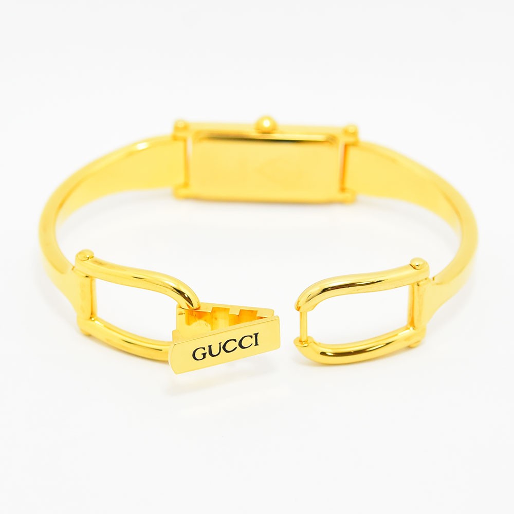 VINTAGE WATCHES FASHIONのGUCCI 1500Lレディースバングルウォッチ。ゴールドトーンの長方形ケースとエレガントな留め具が特徴。