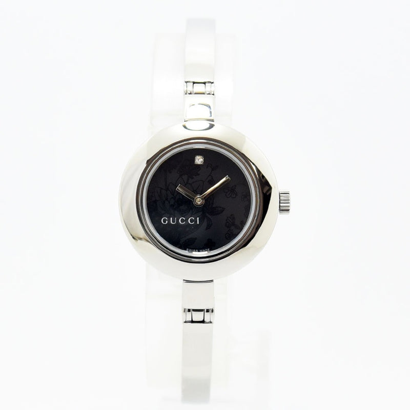 VINTAGE WATCHES FASHIONのGUCCIレディースバングルウォッチ。シルバーのステンレス製で、ブラックの文字盤にフローラル柄と12時のダイヤモンドが輝くエレガントな腕時計。