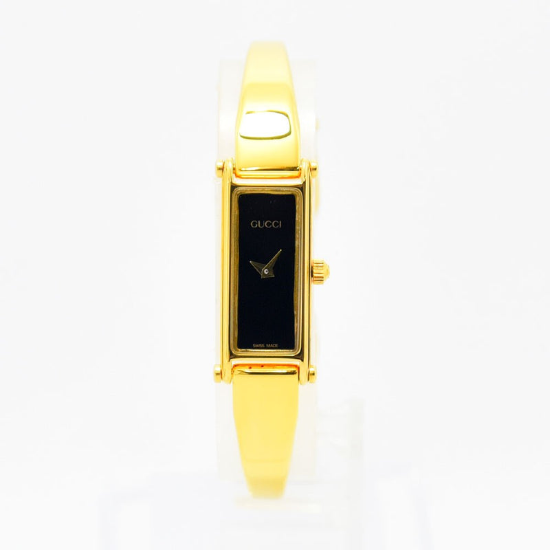 VINTAGE WATCHES FASHIONのGUCCI 1500シリーズ、ゴールドカラーのバングルウォッチ。ブラックの長方形文字盤がエレガントなレディース腕時計