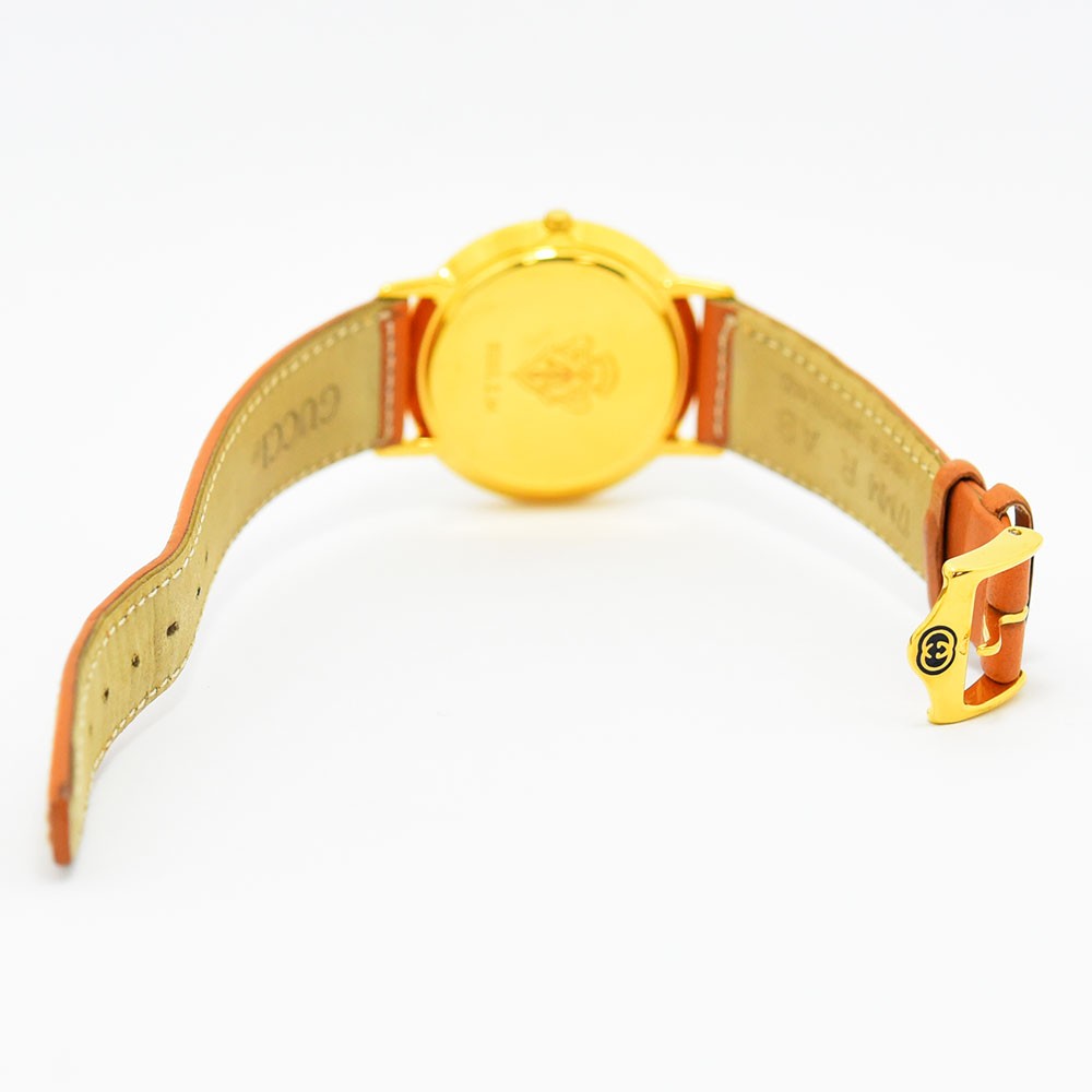 VINTAGE WATCHES FASHIONのグッチ製ヴィンテージ腕時計。オレンジのレザーベルトとゴールドのバックルが特徴的な背面ビュー。