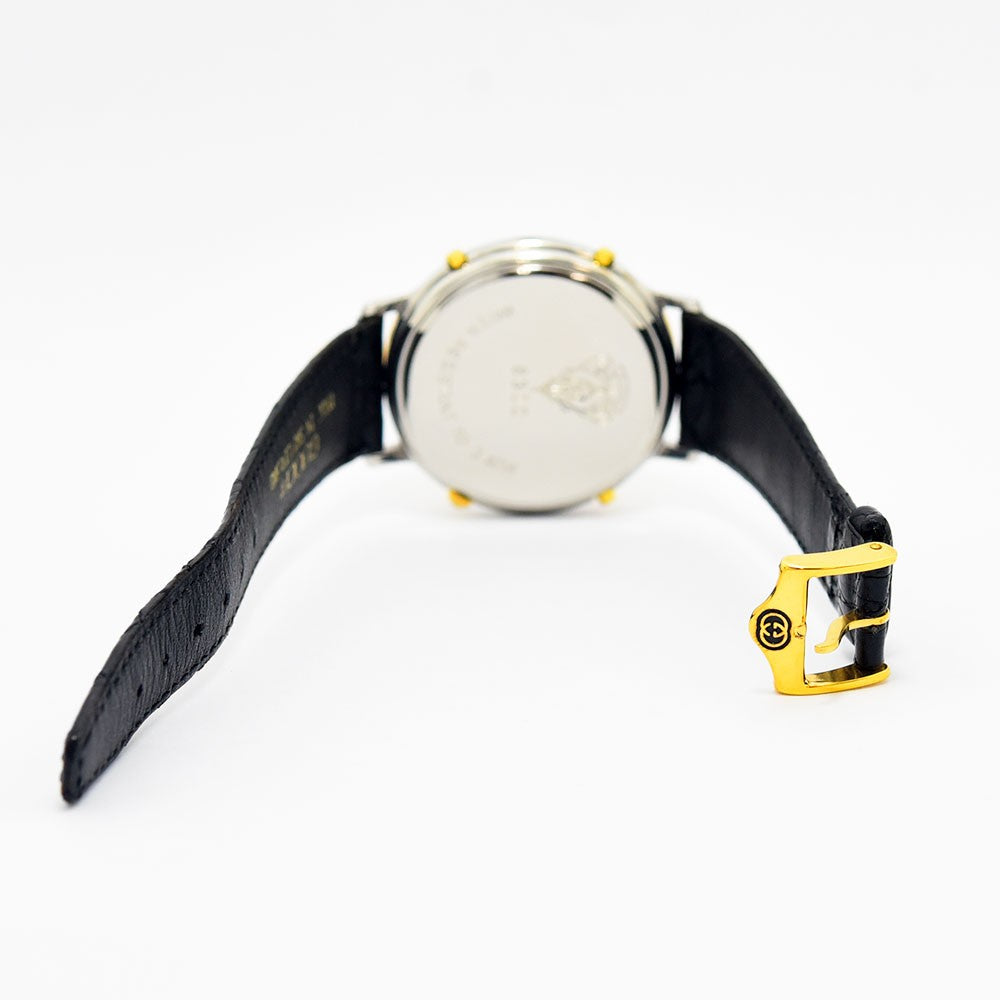 VINTAGE WATCHES FASHIONのGucciヴィンテージウォッチ8300モデル。ブラックの型押しレザーベルトとゴールドのロゴ入りバックルが特徴的な背面ビュー。