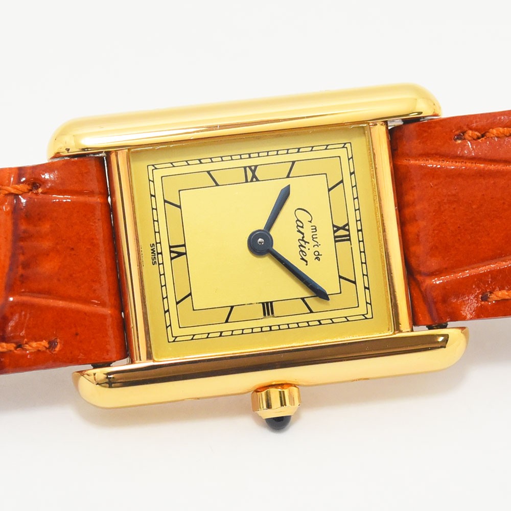 VINTAGE WATCHES FASHIONのMust de Cartier Tankウォッチ、ゴールドトーンケース、クリーム色の文字盤、ローマ数字、オレンジのアリゲーター型押しレザーストラップ。